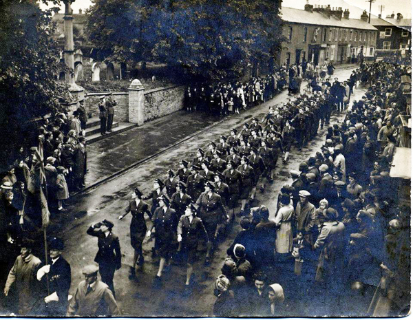 Parade marching past war memorial